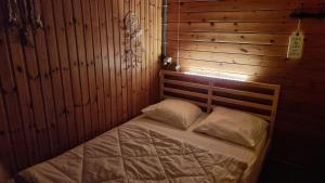 a bedroom with a bed in a wooden wall at Séjour cosy au Chamily in Somme-Leuze