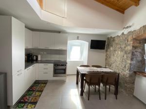 a kitchen with a table and chairs in a room at Apartments Bea in Lovran