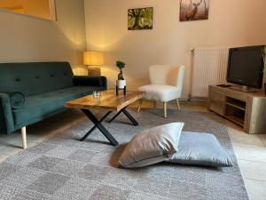 a living room with a green couch and a coffee table at Naturnahes, neu eingerichtetes Apartment mit 1 Schlafzimmer in Neu Gaarz