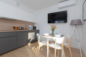 a kitchen with a table and chairs in a kitchen at Horizon Park Apartment by Renters in Dziwnówek