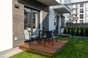 a patio with chairs and a table on a deck at Horizon Park Apartment by Renters in Dziwnówek
