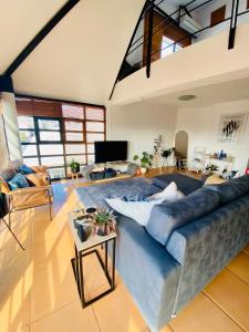 a living room with a blue couch and a tv at Loft 2 - De Waterkant in Cape Town