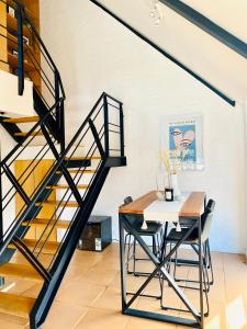 a dining room with a table and a staircase at Loft 2 - De Waterkant in Cape Town
