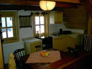 eine Küche mit einem Tisch und einer Obstschale darauf in der Unterkunft Chalet Tatranec in Štôla