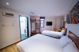 una camera d'albergo con due letti e una porta scorrevole in vetro di The Point Boutique Hotel a Johor Bahru