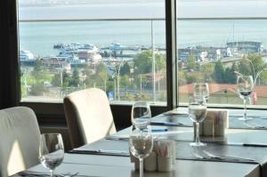 a table with wine glasses and a view of the ocean at Wes Hotel in Kocaeli