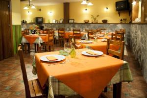 un ristorante con tavoli e sedie con tovaglia arancione di Hotel Rural Cristania a Caminomorisco