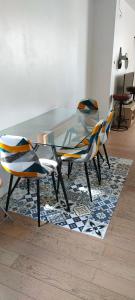 una mesa de cristal y 2 sillas sobre una alfombra en Logement de standing à 9min du centre de Paris, en Colombes