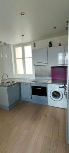 a kitchen with a washing machine and a washer at Logement de standing à 9min du centre de Paris in Colombes
