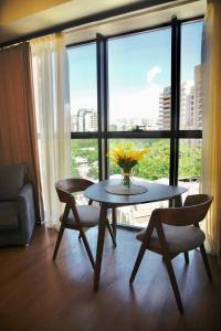 einen Tisch und Stühle in einem Zimmer mit einem großen Fenster in der Unterkunft City Center Appartment at Buzand st. in Yerevan