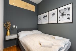 a bedroom with a bed with four pictures on the wall at Trendy apt with - smart TV, coffee machine in Meidling in Vienna