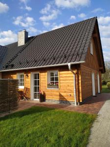 ein Holzhaus mit einer Veranda und einem Hof in der Unterkunft Ferienwohnung - Am Tannenwald in Burg Kauper