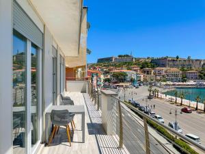 einen Balkon mit einem Tisch und Stühlen sowie Stadtblick in der Unterkunft Appartamento Fronte Mare 20 in Portoferraio
