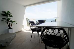 jadalnia ze stołem i krzesłami oraz oknem w obiekcie Deluxe sea view apartment with a swimming pool w mieście Benalmádena