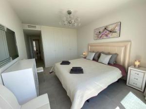 sypialnia z dużym łóżkiem i dwoma ręcznikami na nim w obiekcie Deluxe sea view apartment with a swimming pool w mieście Benalmádena