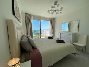 sypialnia z dużym łóżkiem i oknem w obiekcie Deluxe sea view apartment with a swimming pool w mieście Benalmádena