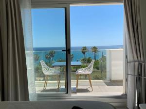 pokój z balkonem ze stołem i krzesłami w obiekcie Deluxe sea view apartment with a swimming pool w mieście Benalmádena +21 zdjęć