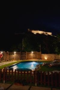a swimming pool in a yard at night at Hotel Don Marcos in Osma