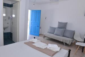 a living room with a couch and a blue door at Papikinou Studios in Adamantas +19 photos
