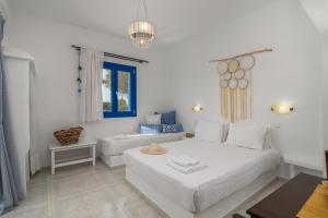 a white bedroom with a bed and a window at Anamnisi Studio in Adamantas