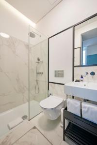 a bathroom with a sink and a toilet and a shower at OnJ S. Lazaro Lisboa in Lisbon