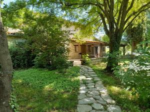 um caminho de pedra em frente a uma casa com árvores em Agriturismo del Frontino - Ca' Benvenuto em Acqualagna