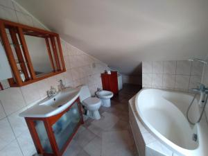 a bathroom with a tub and a toilet and a sink at Agroturystyka Pod Kogutem in Zamość