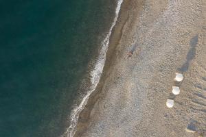 an overhead view of a beach with two footprints in the sand at Amalthia Villa, Heated Pool & Walk to the Beach, By ThinkVilla in Tavronitis