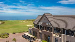 an aerial view of a house with the ocean in the background at Fynbos Golf and Country Estate in Eersterivierstrand