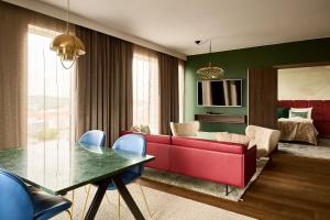 a living room with a red couch and a table at ProfilHotels Halmstad Plaza in Halmstad