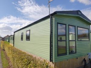 un tren verde con ventanas a un lado en Nidd Way Holiday Let, en Knaresborough