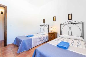 sypialnia z dwoma łóżkami i komodą oraz łóżkiem sidx sidx sidx sidx w obiekcie Mirador de la Encina w mieście Valle de Abdalagís
