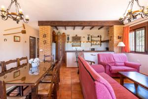 ein Wohnzimmer mit einem Tisch und rosa Stühlen in der Unterkunft Mirador de la Encina in Valle de Abdalagís