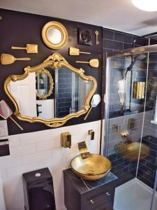 a bathroom with a sink and a mirror at Alice in Wonderland cottage by the sea in Torquay