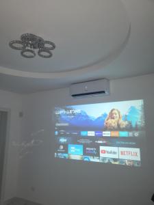 a tv hanging on a wall with a large screen at B&B WHITE HOUSE in Pulsano
