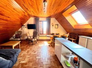 a kitchen and living room with a wooden ceiling at Appartement 6 couchages à proximité du plan d'eau in Saint-Sauveur