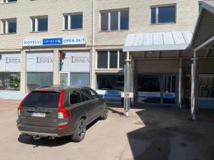 a car parked in a parking lot in front of a building at Hotelli Uninen Kotka in Kotka
