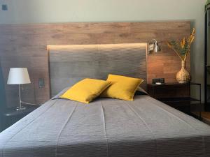 a bedroom with a bed with two yellow pillows at Lost & Found - Guesthouse & Suites in Albufeira