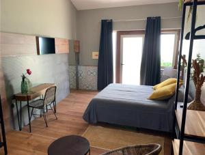 1 dormitorio con cama, mesa y ventana en Lost & Found - Guesthouse & Suites, en Albufeira