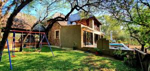 a house with a yard with a swing at Loerie Escape - Marloth Park in Marloth Park