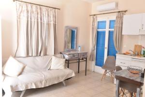 a living room with a white couch and a table at Papikinou Studios in Adamantas