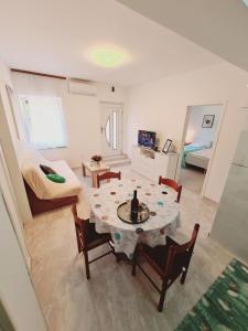 a living room with a table and chairs and a bedroom at Apartments Viktorija in Pula