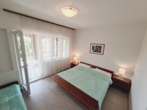a bedroom with a bed and a large window at Apartments Viktorija in Pula