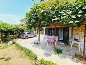 a house with a table and a tree in front of it at Apartments Viktorija in Pula