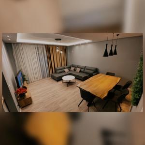 - un salon avec un canapé et une table dans l'établissement Hanna Apartment, à Tirana