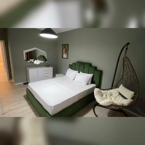 - une chambre avec un lit, une chaise et un miroir dans l'établissement Hanna Apartment, à Tirana