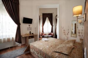 Schlafzimmer mit einem Bett, einem Schreibtisch und einem Fenster in der Unterkunft Vinci Apartman Szombathely in Szombathely