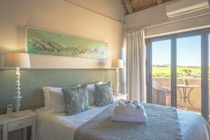 ein Schlafzimmer mit einem Bett und einem Handtuch darauf in der Unterkunft Fynbos Golf and Country Estate in Eersterivierstrand