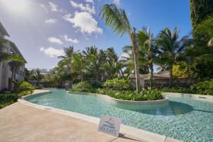 a swimming pool with a sign in front of a resort at Ki Residences Apartments & Penthouse by LOV Mauritius, Pereybere in Pereybere