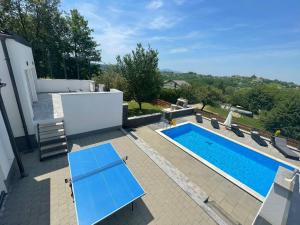 a pool with a blue table and chairs on a patio at Relax zone - Apartmani La ISA in Varaždin Breg